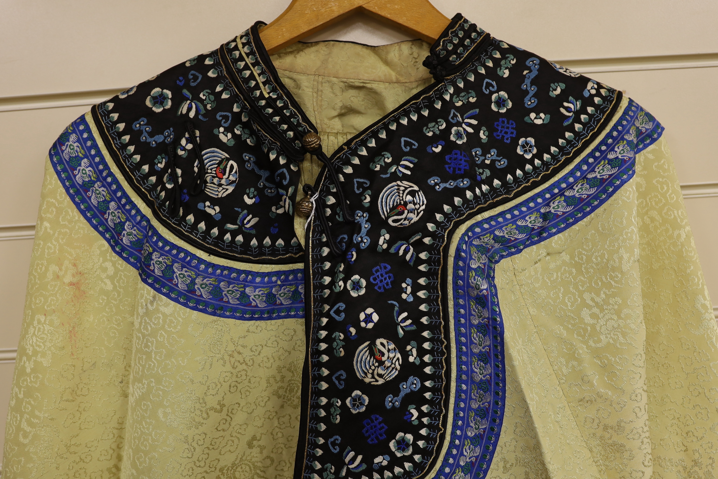 A Chinese late 19th century / early 20th century pale yellow silk damask embroidered robe and an earlier similar skirt embroidered with front panels of flowers and birds